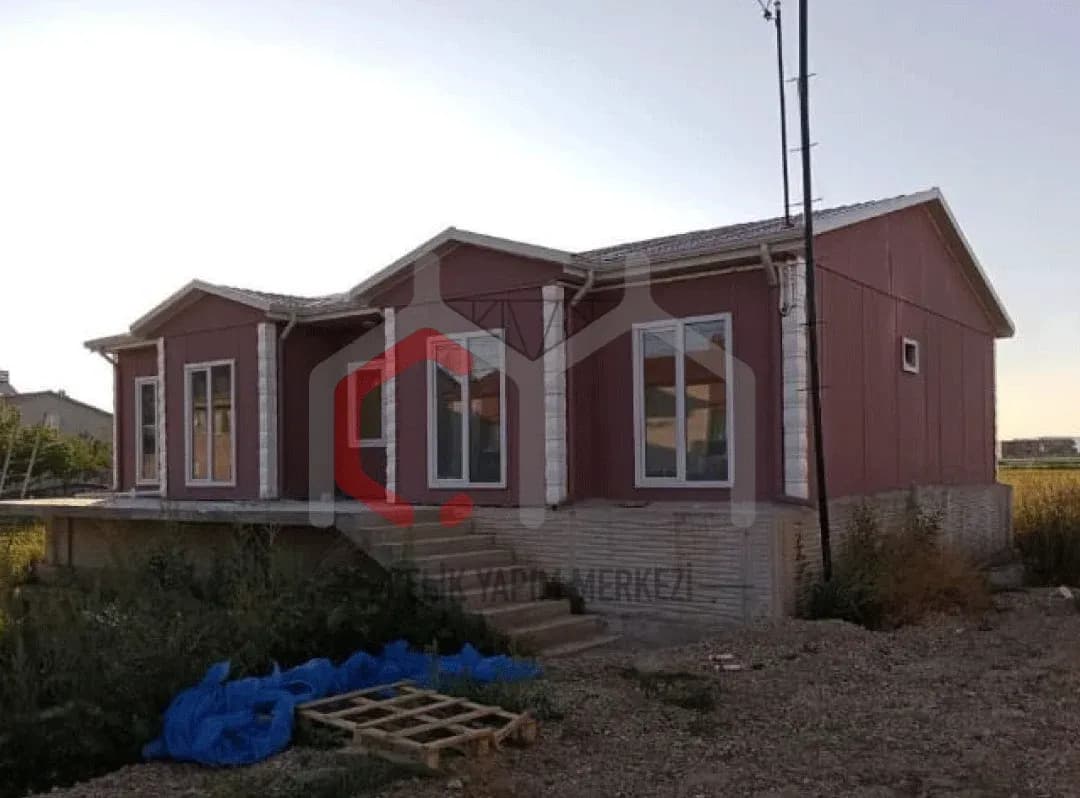 Üç alınlıklı tek katlı prefabrik ev ve giriş merdiveni