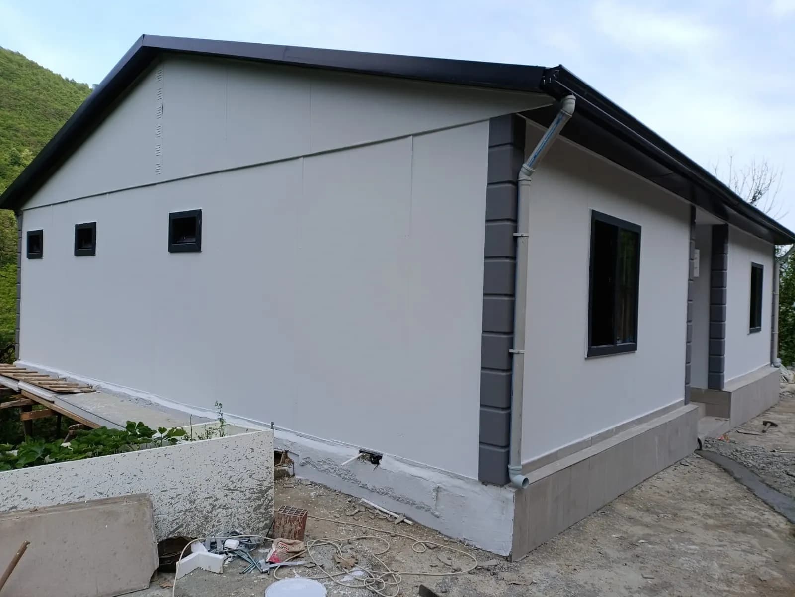 Beyaz panel cepheli prefabrik evin köşe ve pencere detayı