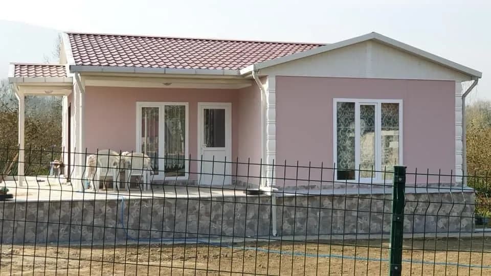 Pembe cepheli, kiremit kırmızısı çatılı tek katlı prefabrik ev