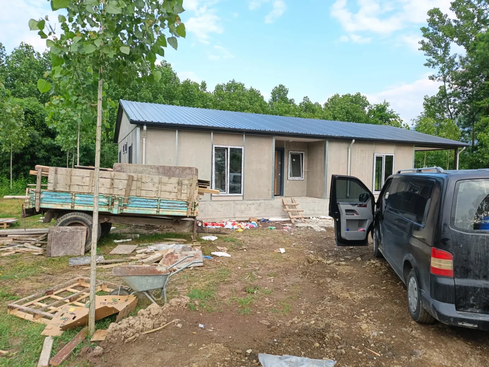Mavi çatılı tek katlı prefabrik ev, montaj sonrası saha