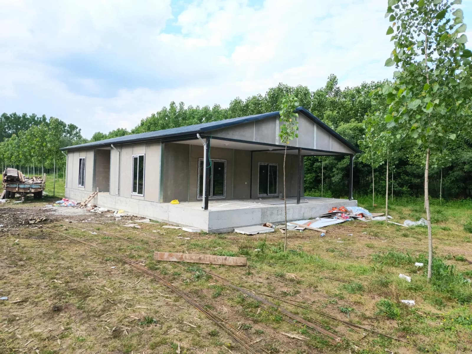 Geniş verandalı, gri çatılı tek katlı prefabrik ev