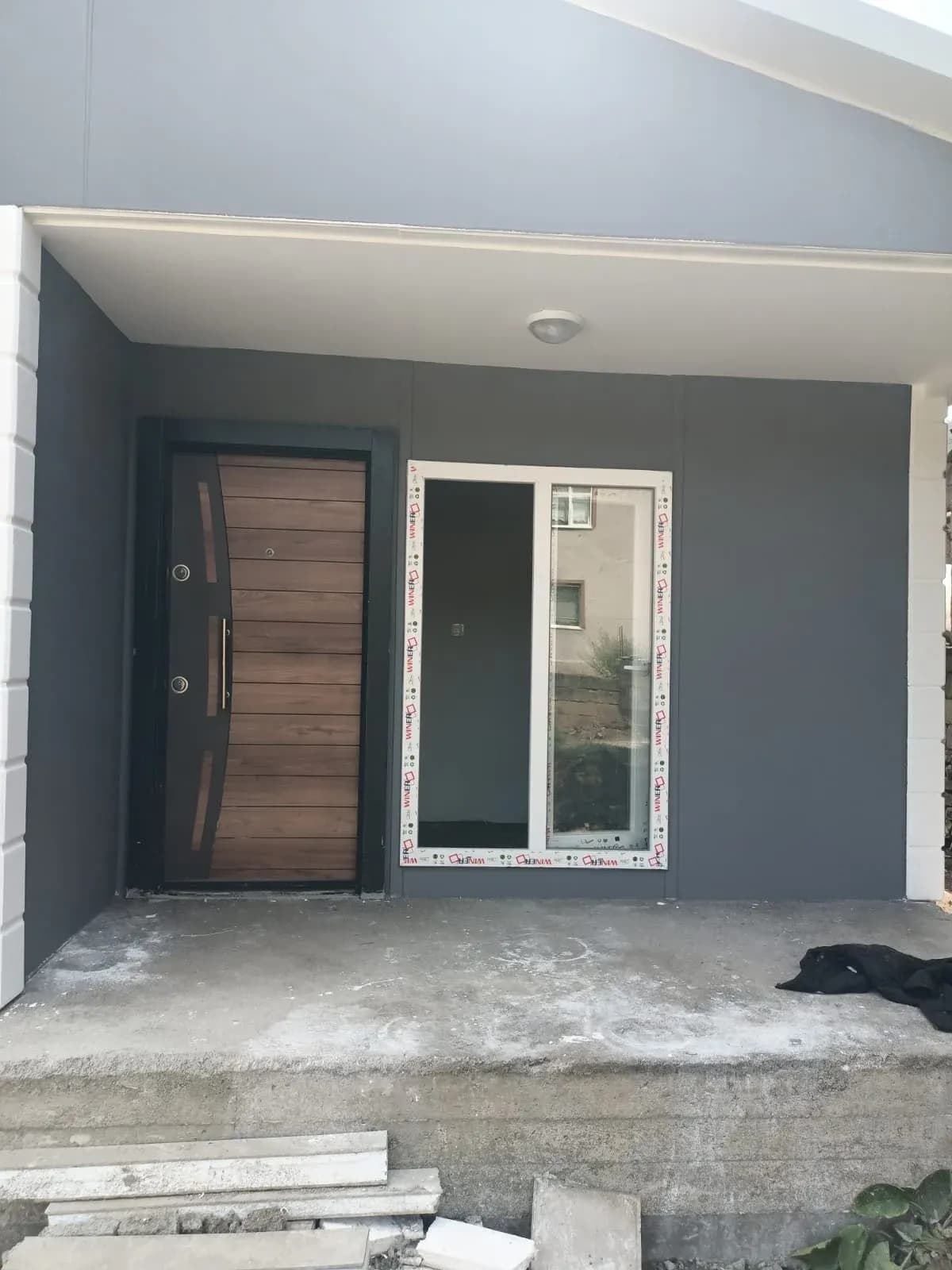 Prefabrik ev girişi: çelik kapı ve sürme cam kapı