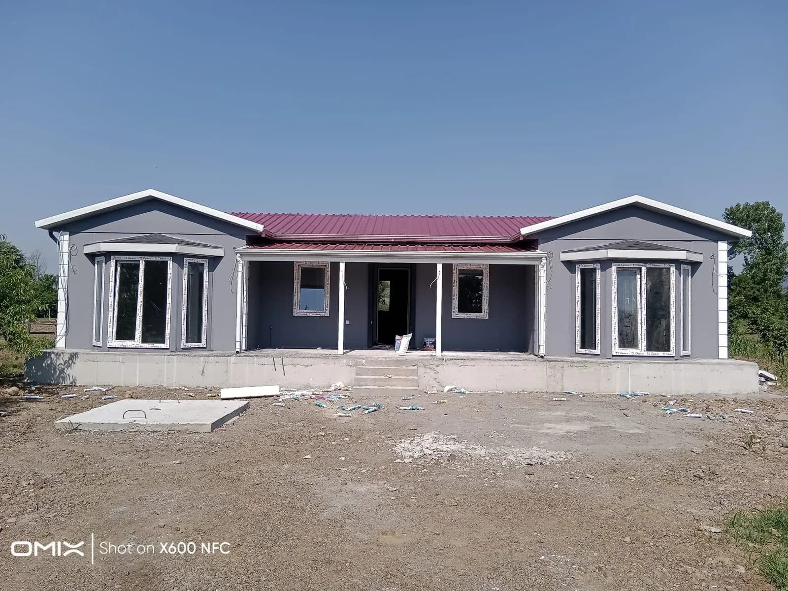 Kırmızı çatılı, geniş cepheli tek katlı prefabrik ev