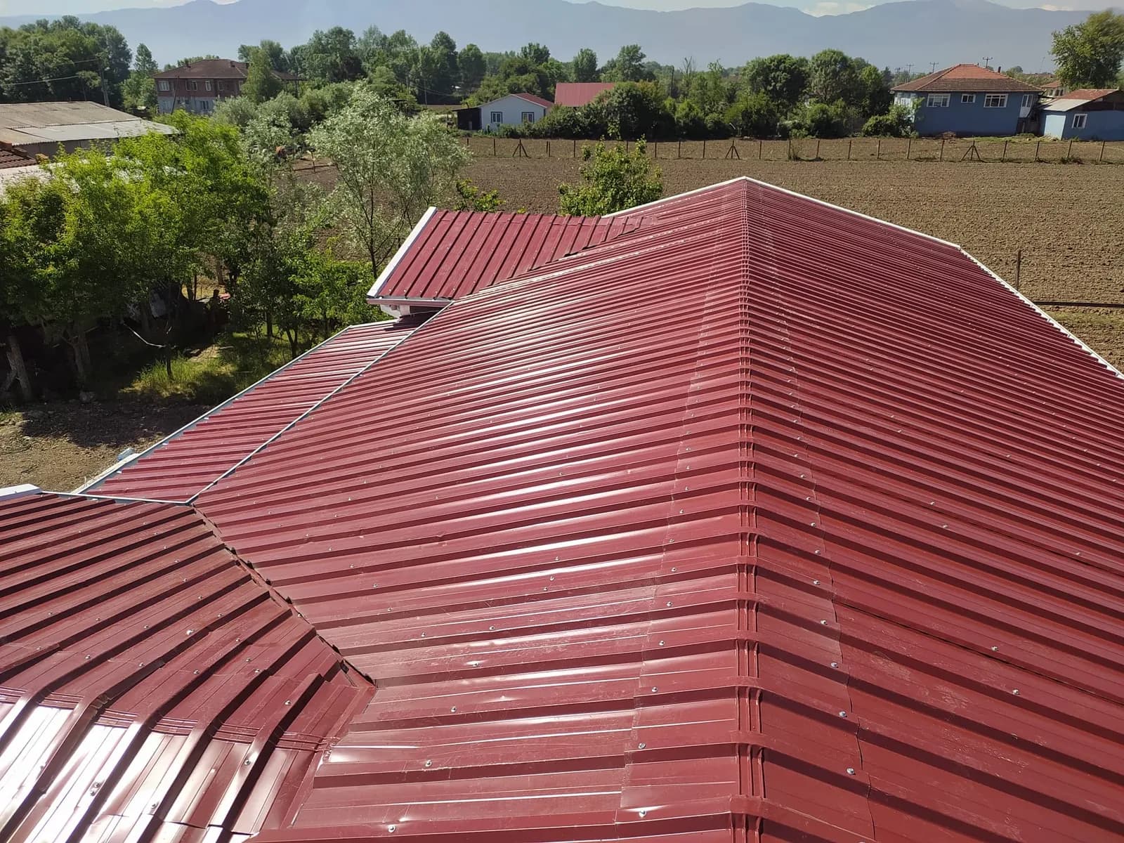 Prefabrik evin kırmızı trapez sac kırma çatısı, yukarıdan