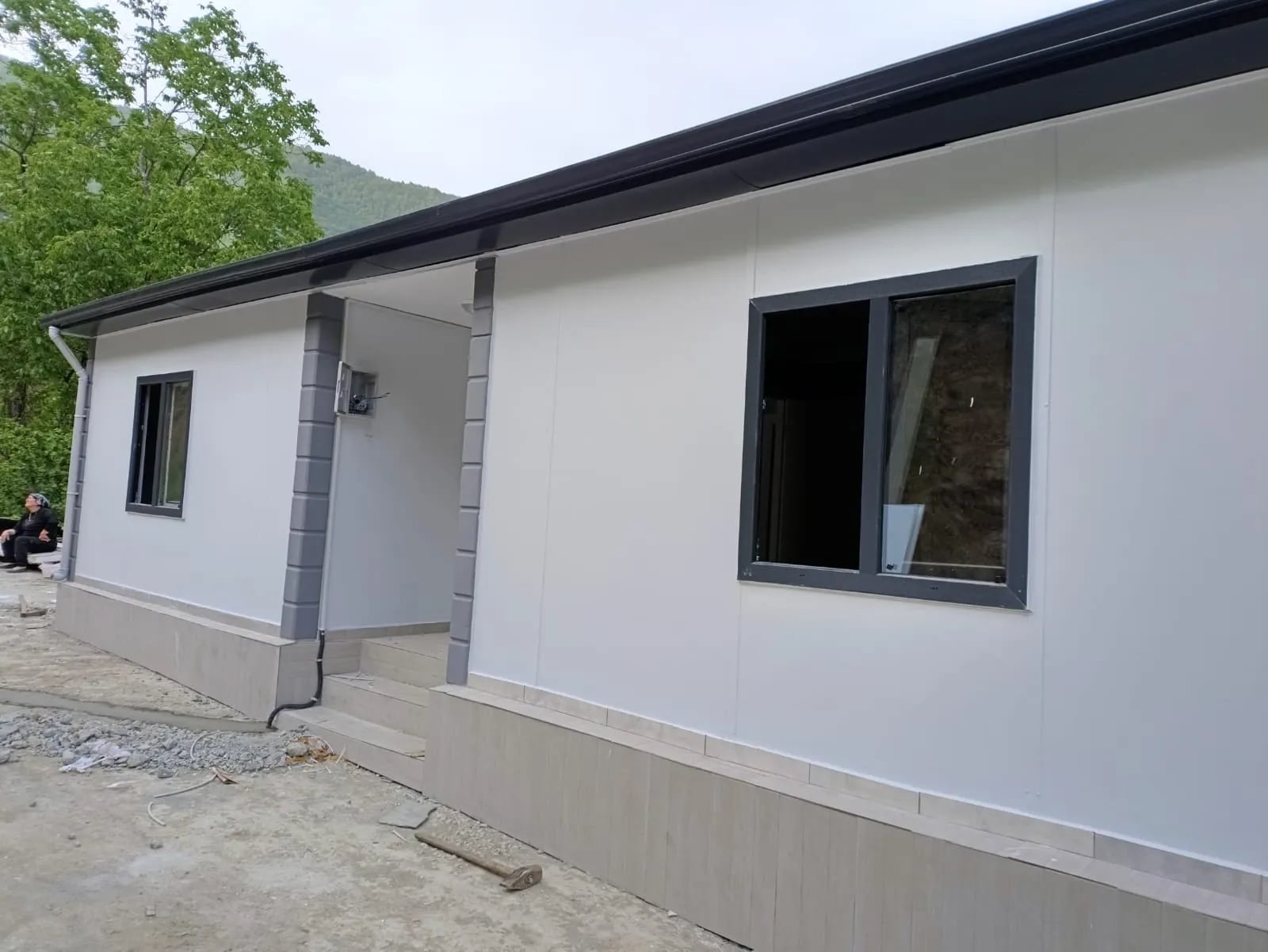Beyaz cepheli prefabrik evde antrasit doğramalı pencere