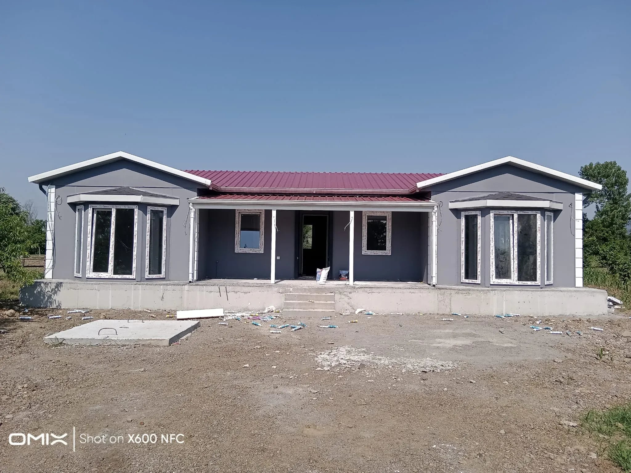 Kırmızı çatılı, geniş cepheli tek katlı prefabrik ev